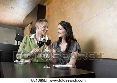 young couple at restaurant raising their glasses View Large Photo Image Stock Image - young couple at restaurant raising their glasses. Fotosearch