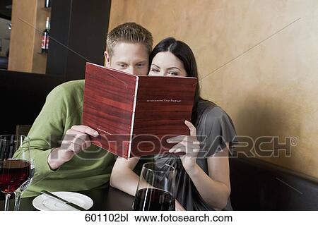 young couple at restaurant reading menu together View Large Photo Image Stock Image - young couple at restaurant reading menu together. Fotosearch