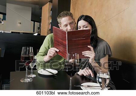 young couple at restaurant reading menu together View Large Photo Image Stock Image - young couple at restaurant reading menu together. Fotosearch