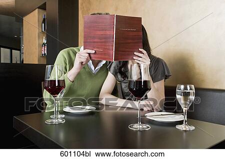 young couple at restaurant reading menu together View Large Photo Image Stock Image - young couple at restaurant reading menu together. Fotosearch