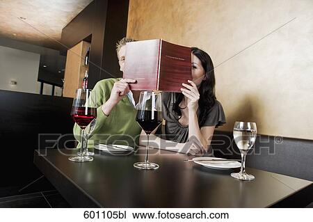 young couple at restaurant reading menu together View Large Photo Image Stock Image - young couple at restaurant reading menu together. Fotosearch