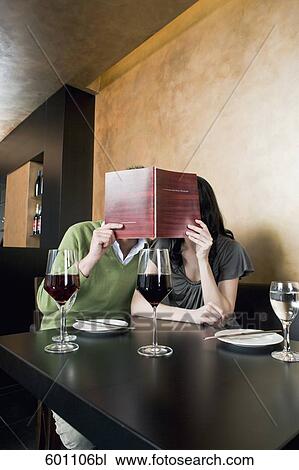 young couple at restaurant reading menu together View Large Photo Image Stock Image - young couple at restaurant reading menu together. Fotosearch