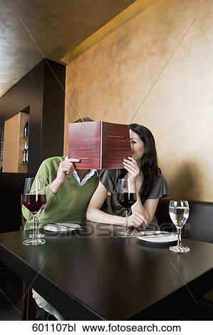 young couple at restaurant reading menu together View Large Photo Image Stock Image - young couple at restaurant reading menu together. Fotosearch