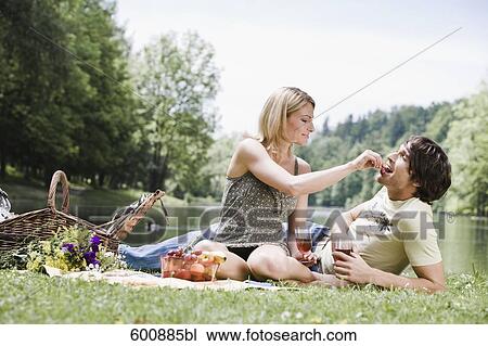 young couple having picnic woman feeding man View Large Photo Image Stock Image - young couple having picnic woman feeding man. Fotosearch