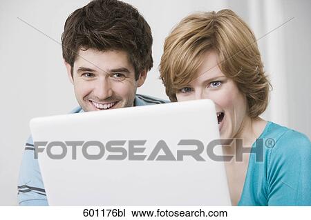 young couple hiding behind laptop computer View Large Photo Image Stock Image - young couple hiding behind laptop computer. Fotosearch