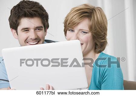 young couple hiding behind laptop computer View Large Photo Image Stock Image - young couple hiding behind laptop computer. Fotosearch