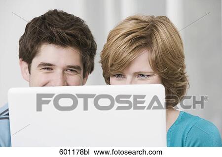 young couple hiding behind laptop computer View Large Photo Image Stock Image - young couple hiding behind laptop computer. Fotosearch