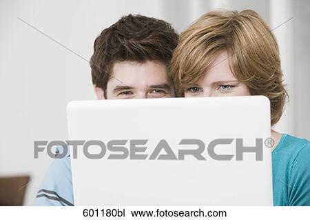 young couple hiding behind laptop computer View Large Photo Image Stock Image - young couple hiding behind laptop computer. Fotosearch