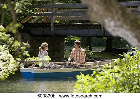 Stock Image - young couple in rowing boat on lake. Fotosearch