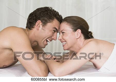 young couple lying on massage bench happily smiling at each other View Large Photo Image Stock Image - young couple lying on massage bench happily smiling at each other. Fotosearch