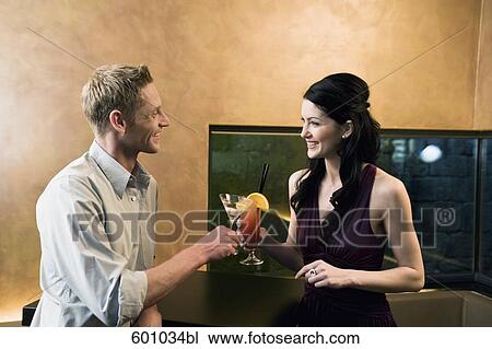 young couple raising glasses in bar View Large Photo Image Stock Image - young couple raising glasses in bar. Fotosearch