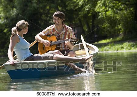 young couple relaxing in rowing boat man playing guitar View Large Photo Image Stock Image - young couple relaxing in rowing boat man playing guitar. Fotosearch