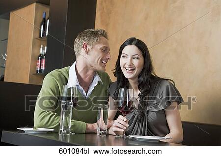 young couple sitting at restaurant with glasses of red wine View Large Photo Image Stock Image - young couple sitting at restaurant with glasses of red wine. Fotosearch