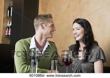 young couple sitting at restaurant with glasses of red wine View Large Photo Image Stock Image - young couple sitting at restaurant with glasses of red wine. Fotosearch