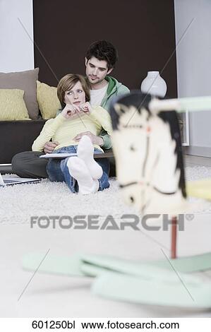 young couple sitting at with rocking horse in foreground View Large Photo Image Stock Image - young couple sitting at with rocking horse in foreground. Fotosearch