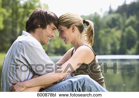 young couple sitting in tender embrace by lake View Large Photo Image Stock Image - young couple sitting in tender embrace by lake. Fotosearch