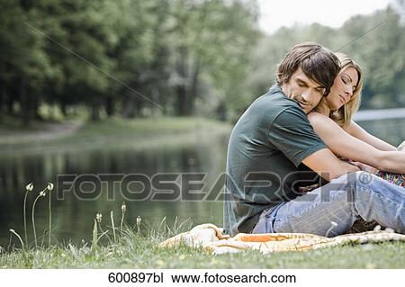 young couple sitting in tender embrace in park View Large Photo Image Stock Image - young couple sitting in tender embrace in park. Fotosearch