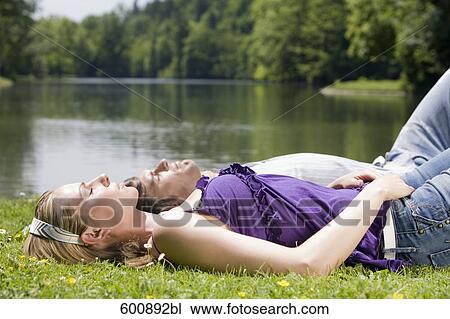 young couple taking a nap in a park View Large Photo Image Stock Image - young couple taking a nap in a park. Fotosearch