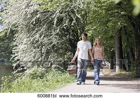 young couple walking hand in hand through park View Large Photo Image Stock Image - young couple walking hand in hand through park. Fotosearch