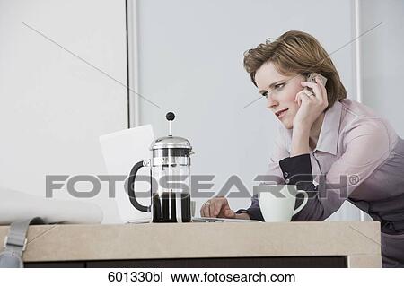 young woman at morning talking on telephone and working with computer View Large Photo Image Stock Image - young woman at morning talking on telephone and working with computer. Fotosearch