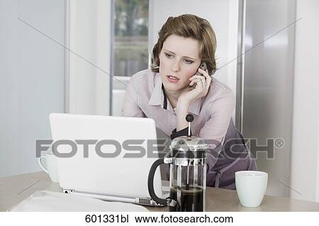 young woman at morning talking on telephone and working with computer View Large Photo Image Stock Image - young woman at morning talking on telephone and working with computer. Fotosearch