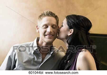 young woman kissing man on cheek in bar View Large Photo Image Stock Image - young woman kissing man on cheek in bar. Fotosearch