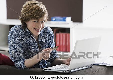 young woman with laptop computer at home holding credit card View Large Photo Image Stock Image - young woman with laptop computer at home holding credit card. Fotosearch