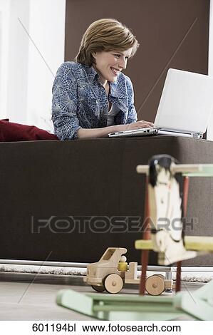 young woman working with laptop computer at home rocking horse in foreground View Large Photo Image Stock Image - young woman working with laptop computer at home rocking horse in foreground. Fotosearch