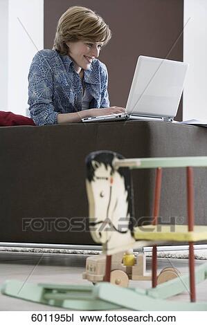 young woman working with laptop computer at home rocking horse in foreground View Large Photo Image Stock Image - young woman working with laptop computer at home rocking horse in foreground. Fotosearch