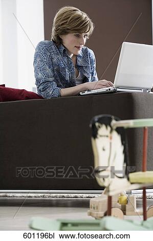 young woman working with laptop computer at home rocking horse in foreground View Large Photo Image Stock Image - young woman working with laptop computer at home rocking horse in foreground. Fotosearch