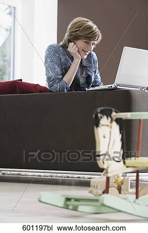 young woman working with laptop computer at home rocking horse in foreground View Large Photo Image Stock Image - young woman working with laptop computer at home rocking horse in foreground. Fotosearch