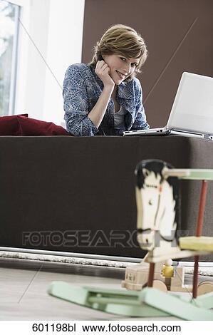 young woman working with laptop computer at home rocking horse in foreground View Large Photo Image Stock Image - young woman working with laptop computer at home rocking horse in foreground. Fotosearch