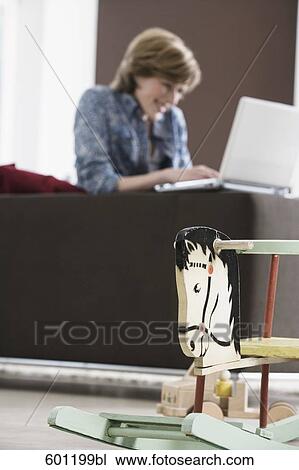young woman working with laptop computer at home rocking horse in foreground View Large Photo Image Stock Image - young woman working with laptop computer at home rocking horse in foreground. Fotosearch