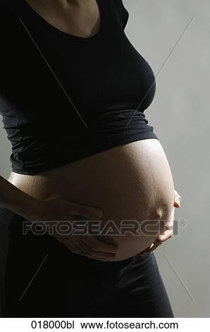 detail of pregnant woman holding her belly View Large Photo Image Stock Image - detail of pregnant woman holding her belly. Fotosearch