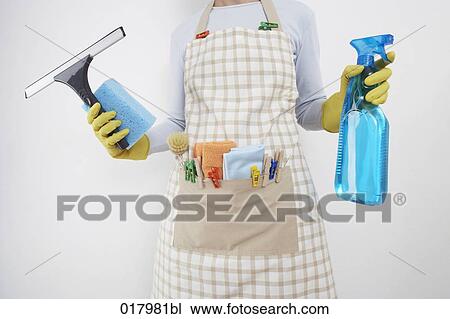 Stock Image - detail of woman ready to do housework holding window cleaner and spray bottle. Fotosearch
