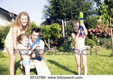 family playing garden with water pistols View Large Photo Image Stock Image - family playing garden with water pistols. Fotosearch