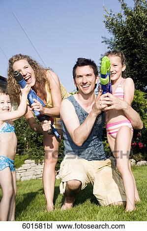 family playing garden with water pistols View Large Photo Image Stock Image - family playing garden with water pistols. Fotosearch