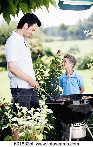 father and son grilling together at barbecue View Large Photo Image Stock Image - father and son grilling together at barbecue. Fotosearch