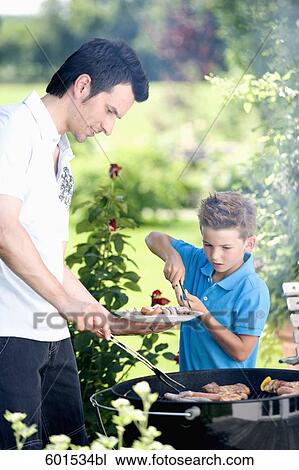 father and son grilling together at barbecue View Large Photo Image Stock Image - father and son grilling together at barbecue. Fotosearch