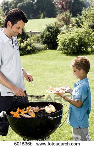 father and son grilling together at barbecue View Large Photo Image Stock Image - father and son grilling together at barbecue. Fotosearch