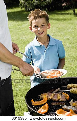 father and son grilling together at barbecue boy holding plate with sausages View Large Photo Image Stock Image - father and son grilling together at barbecue boy holding plate with sausages. Fotosearch