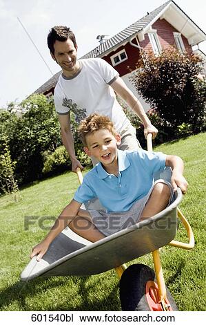 father carrying son in wheelbarrow View Large Photo Image Stock Image - father carrying son in wheelbarrow. Fotosearch