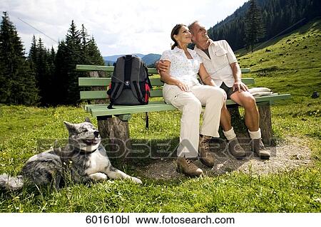full body portrait of mature couple with dog sitting on bench in the mountains View Large Photo Image Stock Image - full body portrait of mature couple with dog sitting on bench in the mountains. Fotosearch