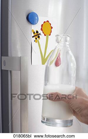 hand holding milk bottle in front of refrigerator View Large Photo Image Stock Image - hand holding milk bottle in front of refrigerator. Fotosearch