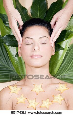 Stock Image - headshot of young woman being massaged. Fotosearch