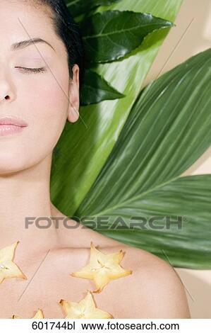headshot of young woman lying on green leaves View Large Photo Image Stock Image - headshot of young woman lying on green leaves. Fotosearch