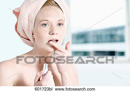 headshot of young woman putting lipstick with finger on mouth View Large Photo Image Stock Image - headshot of young woman putting lipstick with finger on mouth. Fotosearch
