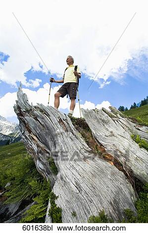 low angle view of mature man standing on log in the mountains View Large Photo Image Stock Image - low angle view of mature man standing on log in the mountains. Fotosearch