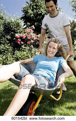 man carrying his wife in wheelbarrow View Large Photo Image Stock Image - man carrying his wife in wheelbarrow. Fotosearch