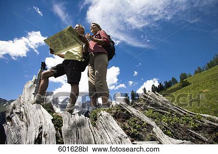 mature couple hiking in the mountains looking at map View Large Photo Image Stock Image - mature couple hiking in the mountains looking at map. Fotosearch